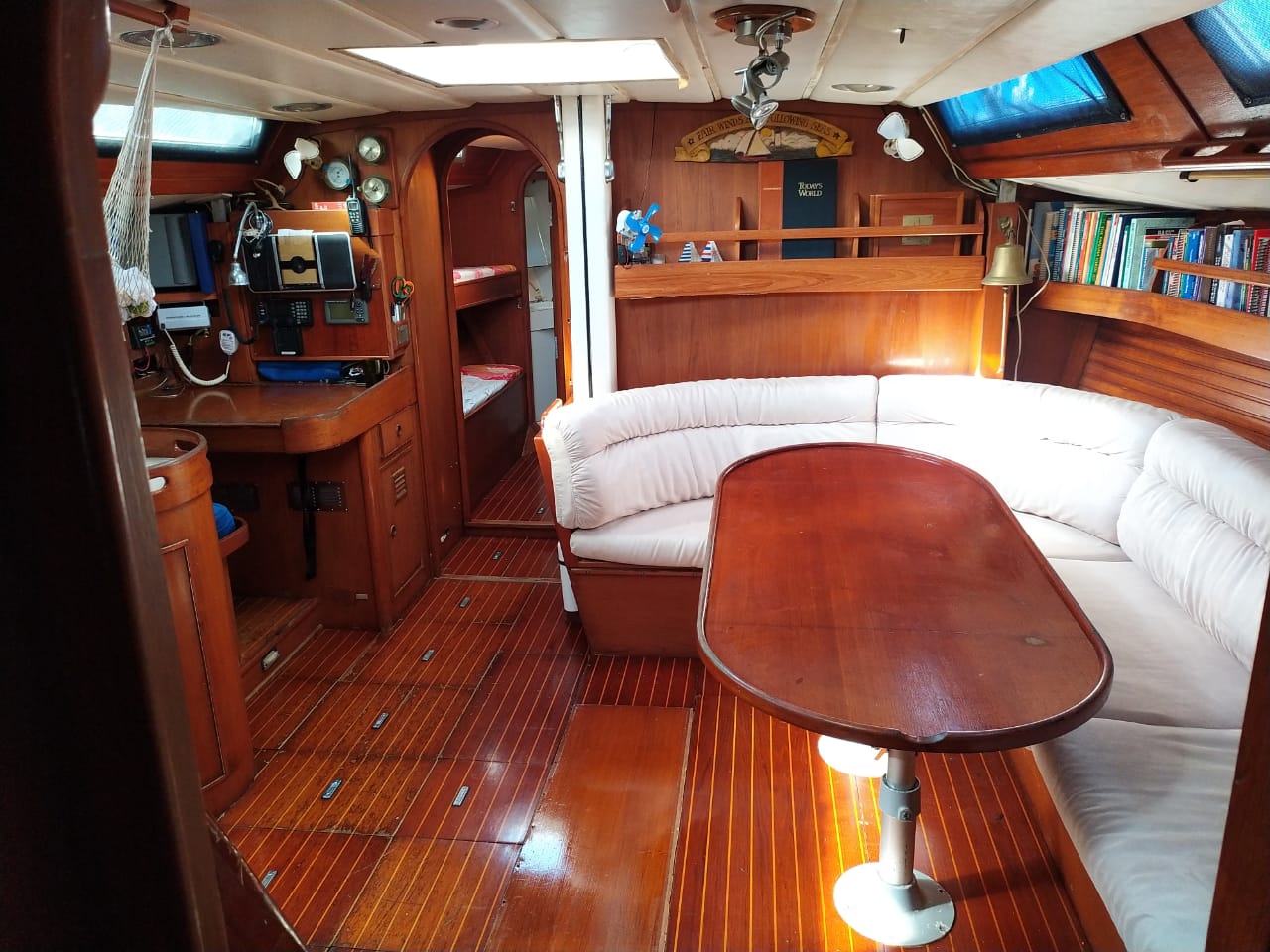 a living area of a boat with a couch and a table. a common area in a hosted sailboat stay with sea gypsy